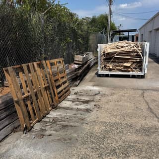 Wood pallets and a dumpster box full of lumber debris