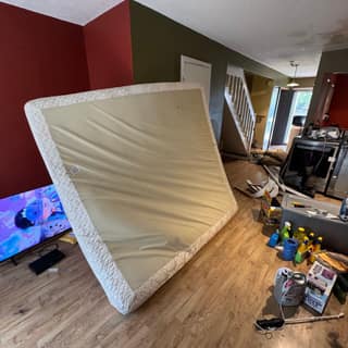 Mattress, TV and household items in a room before a cleanout