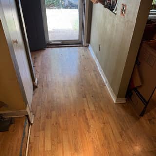Hallway with wood floors swept clean after a cleanout