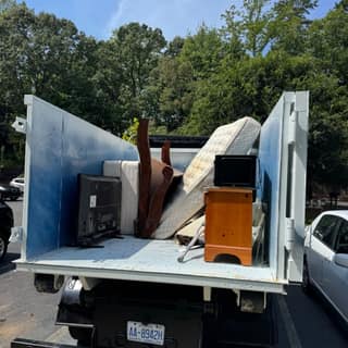 Truck loaded with furniture, a TV and a nightstand