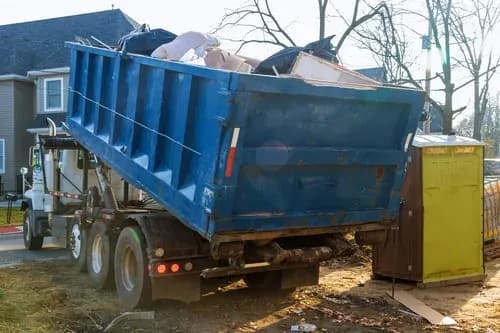 360 Junk Removal truck hauling a loaded dumpster from a Charlotte, NC property